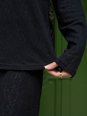 Detail of the black openwork lace on the long-sleeve top
