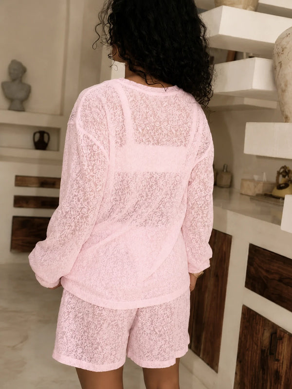 Angled back view of the blush pink long-sleeve lace top